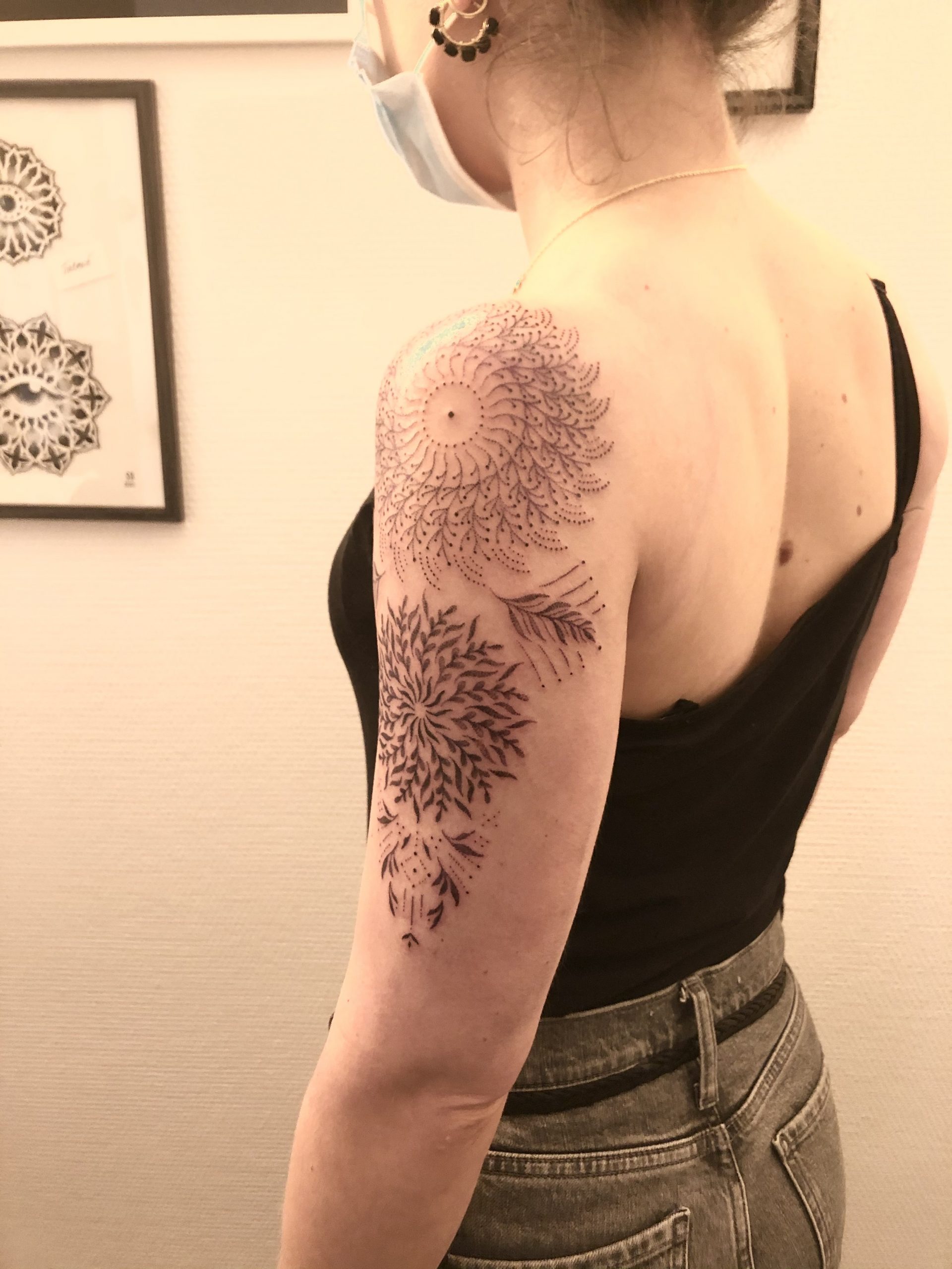 Un tatouage ornemental de rosaces fleuries en travail de points sur le bras