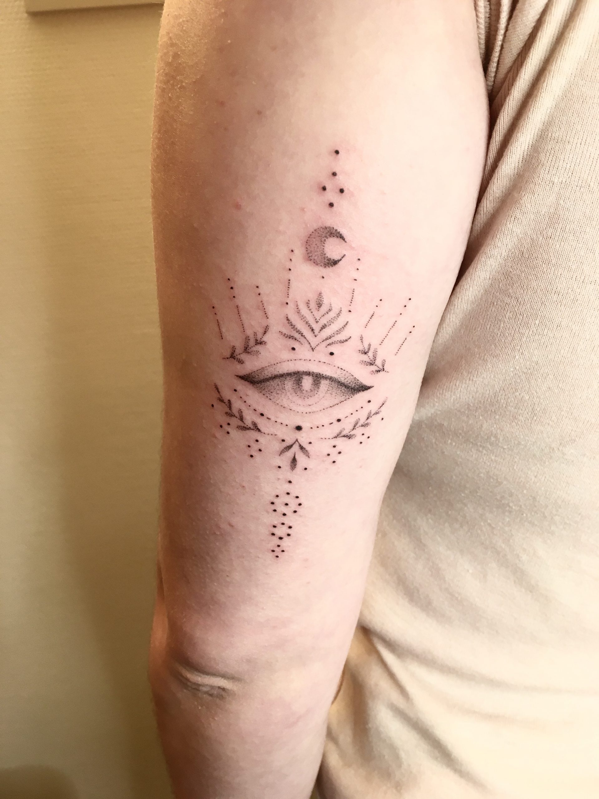 Un tatouage d'un oeil et d'une lune en travail de points