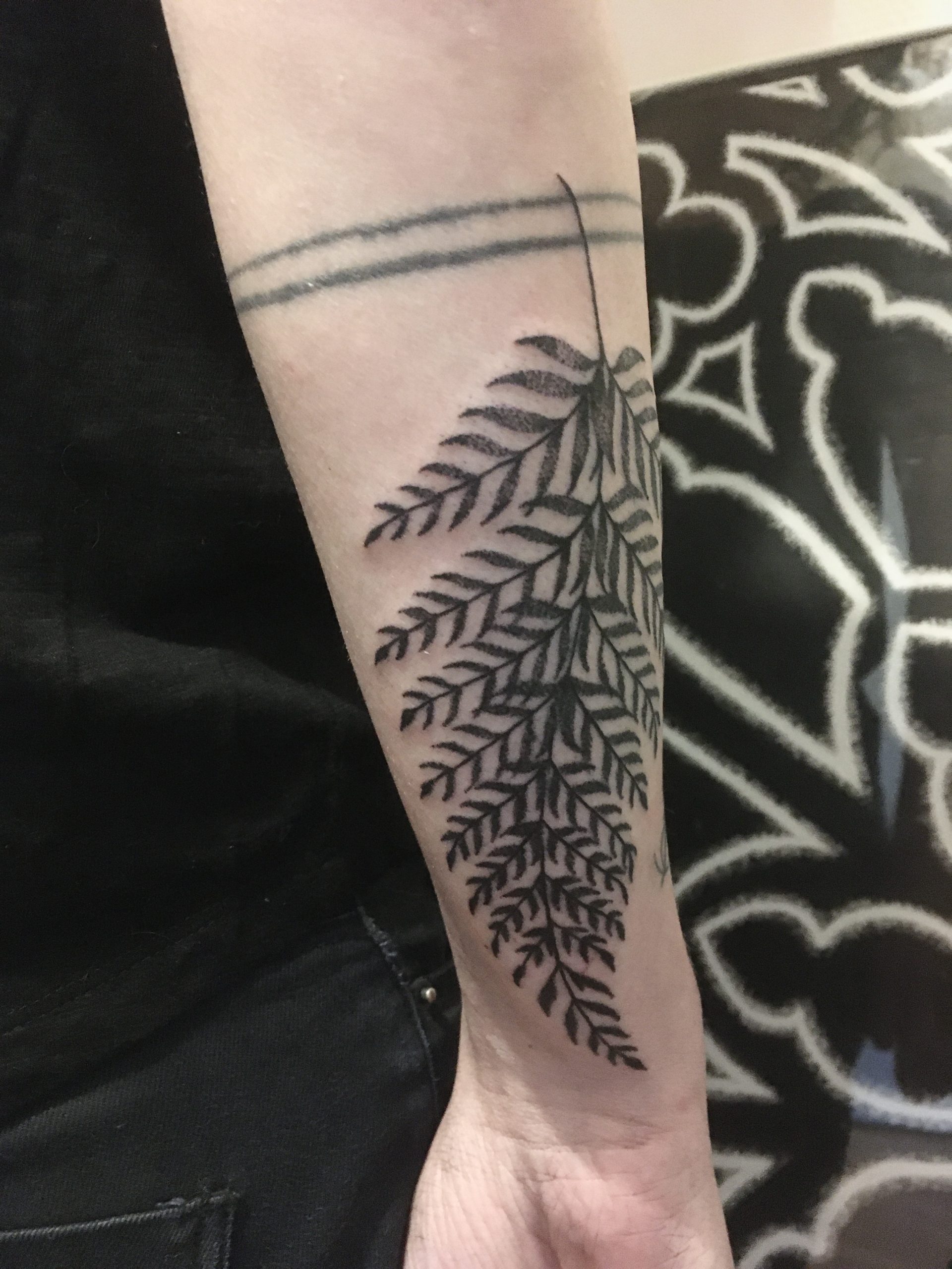 Un tatouage d'une feuille de fougère sur l'avant-bras