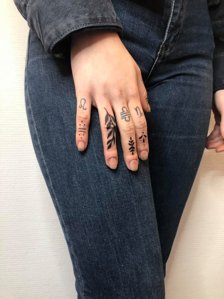 Plusieurs tatouages ornementaux sur les doigts